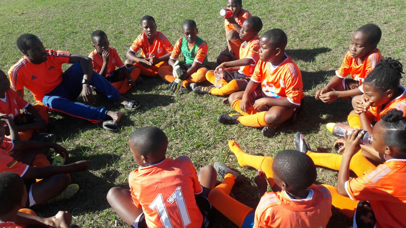 2016-2018 U10 COED Grassroot Soccer Team in a huddle with Coach Holland.